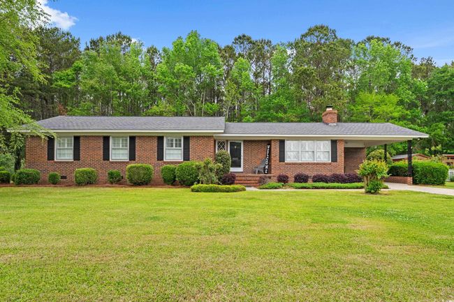 Ranch-style house with a carport, a chimney, concrete driveway, brick siding, and a front yard | Image 31
