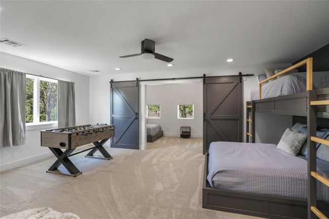 Bedroom featuring a barn door, light colored carpet, baseboards, visible vents, and recessed lighting | Image 26