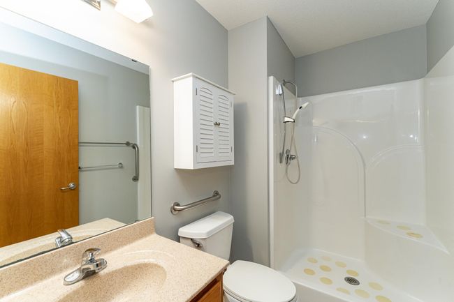 Primary bath offers a nice-sized vanity with hard-surface top and a step-in shower with seating. | Image 11