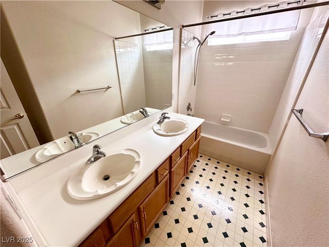 Bathroom featuring tile patterned floors, plenty of natural light, washtub / shower combination, and double vanity | Image 15