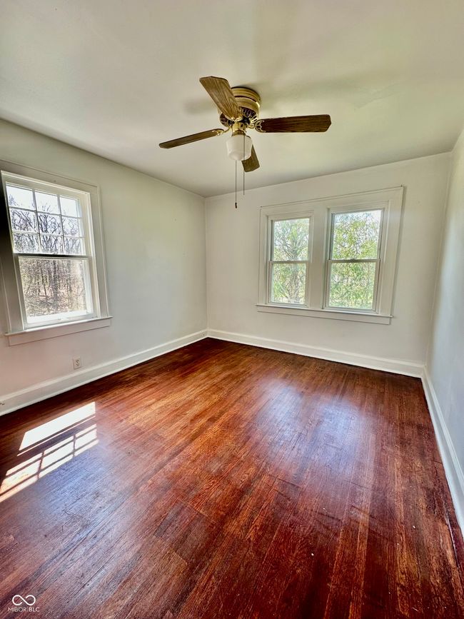 spare room featuring wood finished floors, ceiling fan, baseboards, and a wealth of natural light | Image 33
