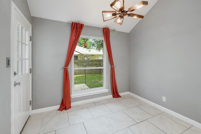 Empty room with baseboards, a ceiling fan, and lofted ceiling | Image 9