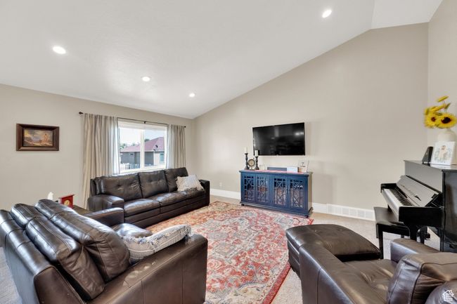 Carpeted living room with lofted ceiling and recessed lighting | Image 4