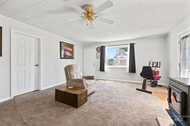 Sitting room featuring carpet, a ceiling fan, and a wood stove | Image 7
