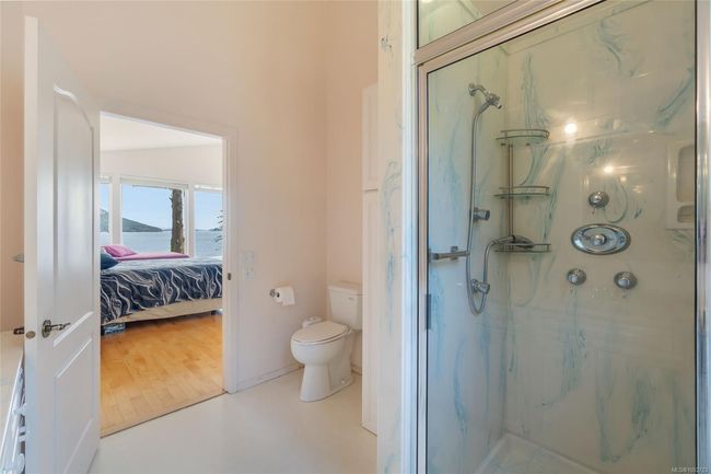 Bathroom with toilet, a marble finish shower, a water view, and ensuite bath | Image 32