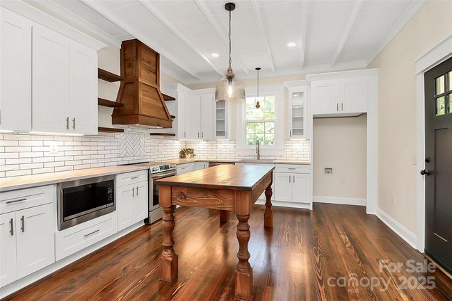 Custom hand-crafted vent hood built from wood original to the home and custom solid wood kitchen island really gives this kitchen the wow factor! | Image 13