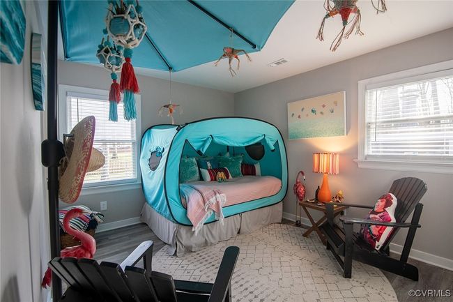 Bedroom with wood finished floors, visible vents, and baseboards | Image 22