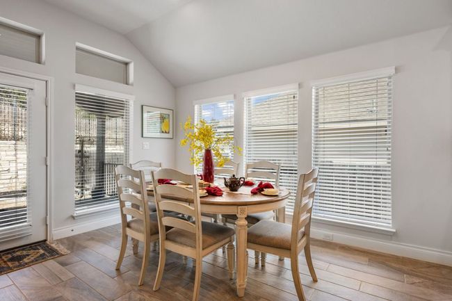Dining area featuring lofted ceiling, light wood-style flooring, and a wealth of natural light | Image 14