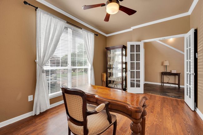 Dining room featuring ornamental molding, french doors, ceiling fan, wood finished floors, and a desk | Image 4