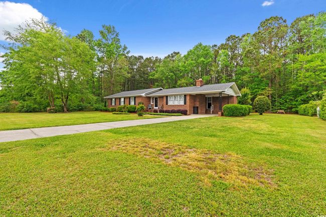 Ranch-style home featuring a front lawn, a chimney, brick siding, and concrete driveway | Image 33