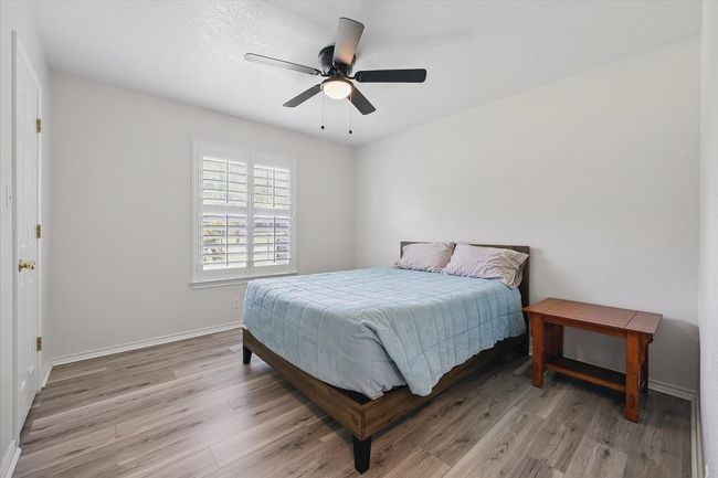 Bedroom with light wood-type flooring, baseboards, and a ceiling fan | Image 20