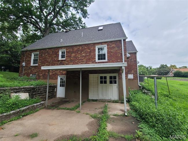 Back of house featuring brick siding, a patio, roof with shingles, and a yard | Image 4
