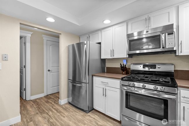 From corner of kitchen looking towards pantry, main level half bath, and garage door entrance | Image 14