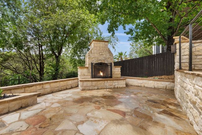 The outdoor fireplace adds a touch of luxury and charm to the backyard, creating a cozy focal point for evening gatherings or quiet nights under the stars. | Image 30