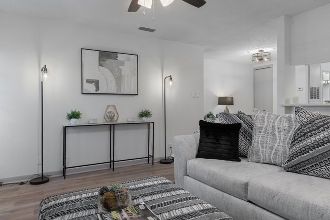 Living room with wood finished floors, visible vents, a ceiling fan, and baseboards | Image 6