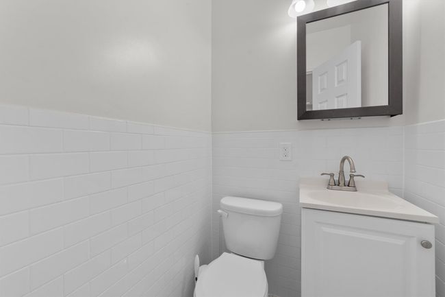 Bathroom with wainscoting, toilet, vanity, and tile walls | Image 19