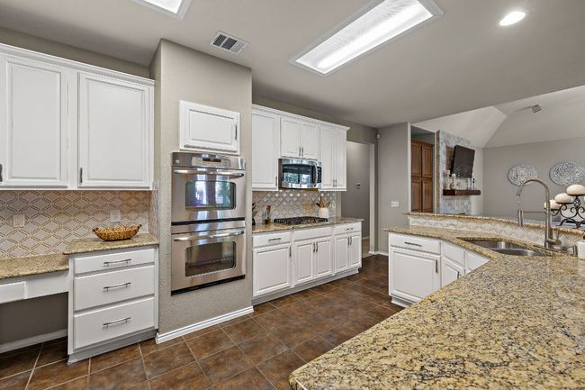 Kitchen featuring a sink, stainless steel appliances, tasteful backsplash, white cabinets, and recessed lighting | Image 14