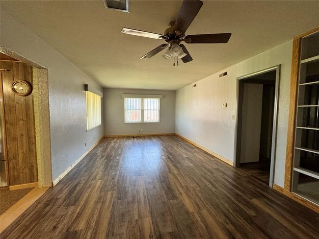 Spare room featuring ceiling fan and dark wood-type flooring | Image 12