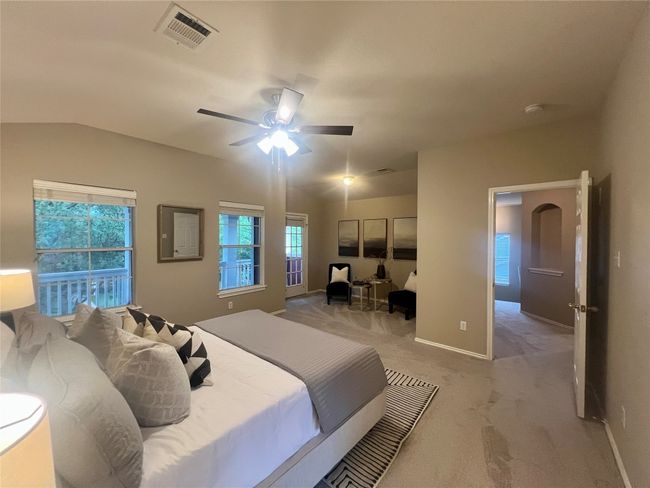 Bedroom featuring light carpet, vaulted ceiling, and a ceiling fan | Image 23