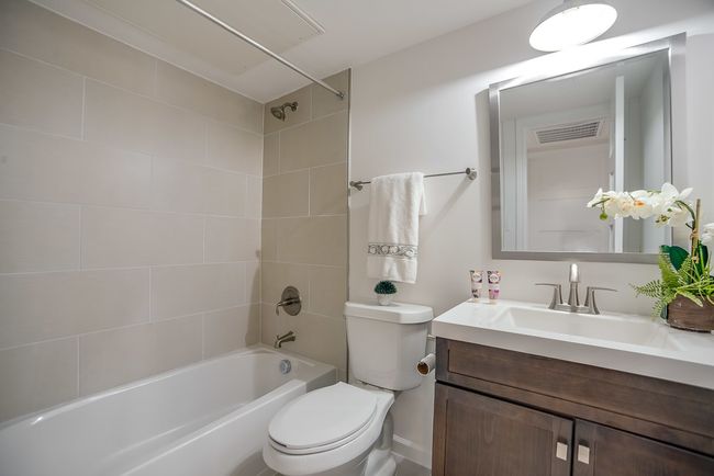 Full bathroom featuring toilet, tiled shower / bath, and vanity | Image 5
