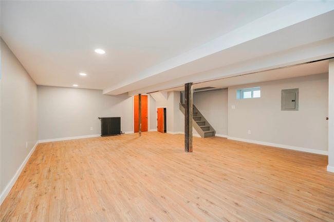 Below grade area with light wood-style flooring, electric panel, recessed lighting, stairway, and baseboards | Image 22