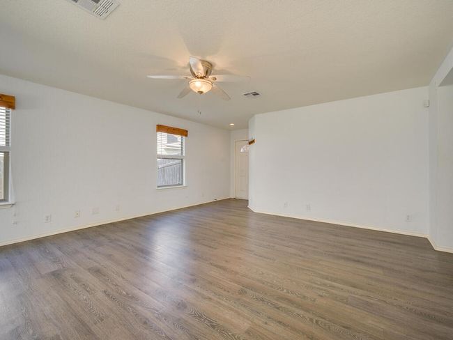 Living room with luxury vinyl wood look flooring and a ceiling fan. | Image 6