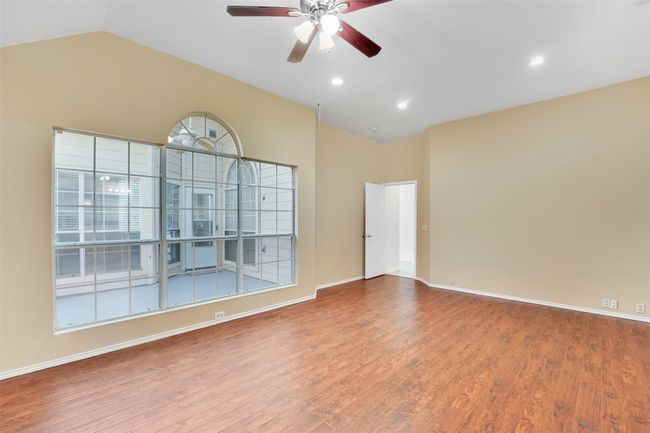 Unfurnished room with hardwood / wood-style floors, vaulted ceiling, and ceiling fan | Image 31