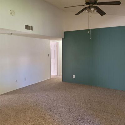 Empty room featuring ceiling fan, carpet flooring, and high vaulted ceiling | Image 2