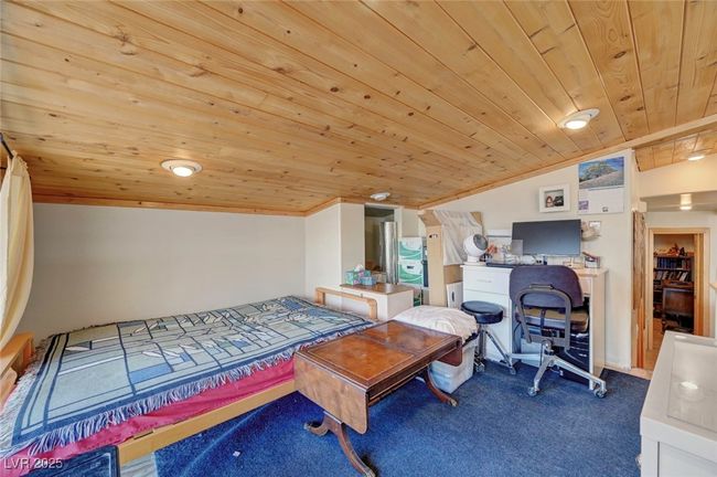 Carpeted bedroom with wood ceiling and lofted ceiling | Image 36