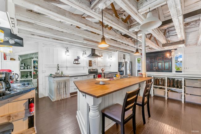Kitchen featuring stainless steel electric stove, exhaust hood, wooden counters, and dark wood-style flooring | Image 8