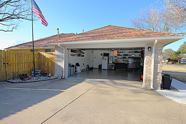 Garage with concrete driveway and fence | Image 9