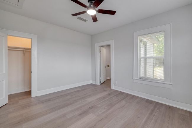 Unfurnished bedroom featuring light wood-style floors, a ceiling fan, and a spacious closet | Image 33