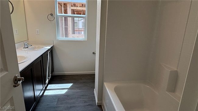 Bathroom with double vanity, wood finished floors, baseboards, and a sink | Image 20