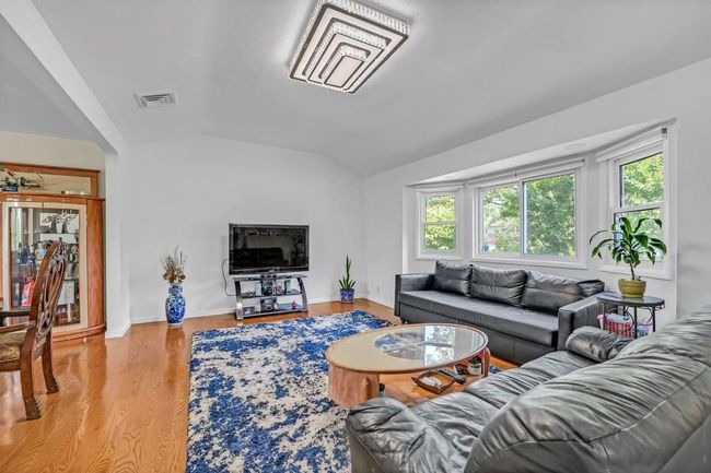Living room with vaulted ceiling and wood finished floors | Image 17