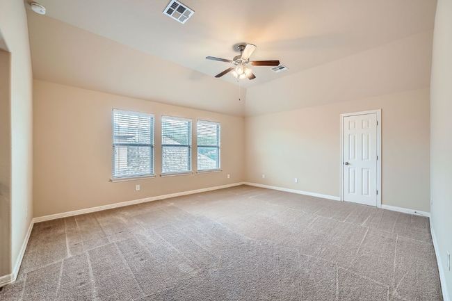 Carpeted empty room with a ceiling fan, a smoke detector, and lofted ceiling | Image 24
