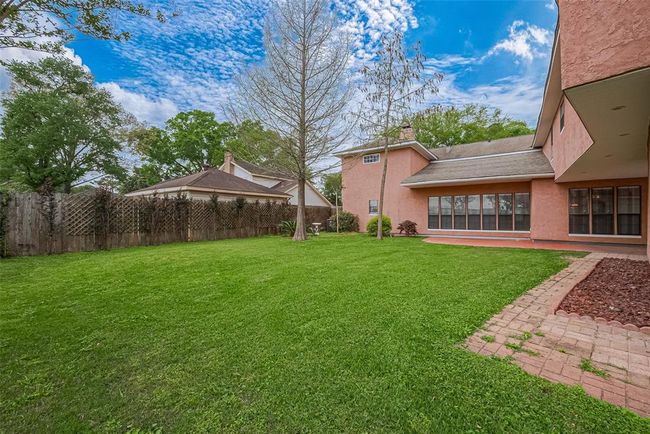 The oversized backyard offers ample green space for gatherings, gardening, or future additions. With mature landscaping and plenty of privacy, this outdoor oasis is ready for playtime or peaceful weekends. | Image 49
