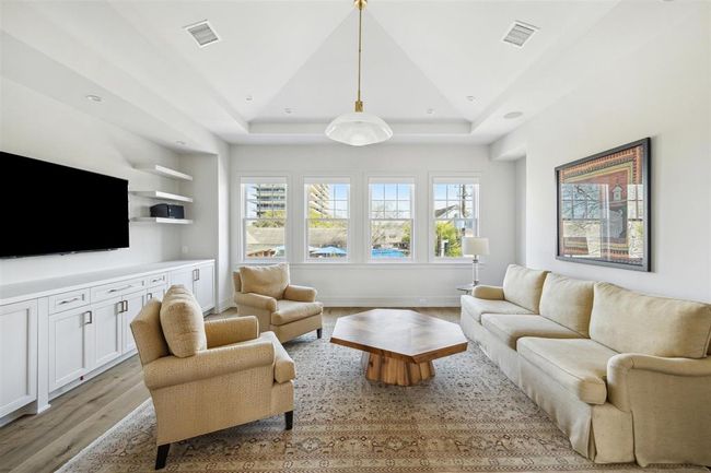 Host unforgettable movie nights in this perfectly positioned second-floor game room. Featuring rich hardwood floors, soaring tray ceilings, and a dedicated space for a personal home theater, this inviting space is designed for entertainment and relaxation. | Image 19