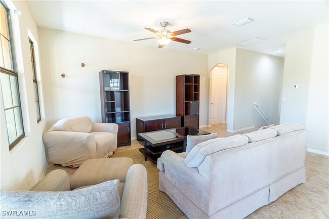 Living area featuring ceiling fan and arched walkways | Image 8