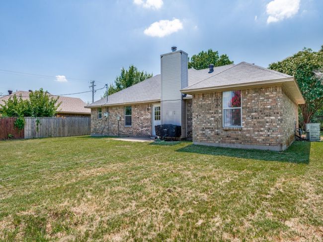 Rear view of property featuring a patio area, a chimney, and brick siding | Image 25