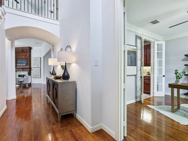 Hall with wood finished floors, ornamental molding, and arched walkways | Image 5