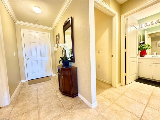 Hall featuring a sink, baseboards, ornamental molding, and light tile patterned floors | Image 22