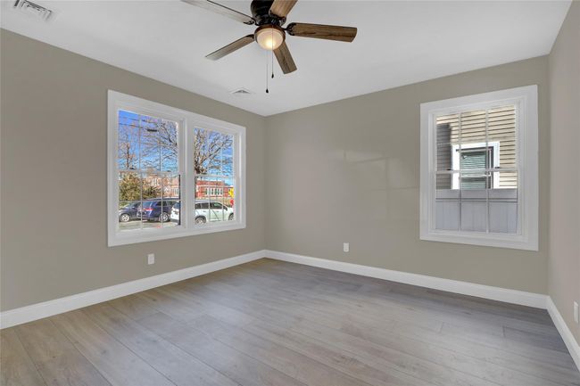 Empty room with visible vents, plenty of natural light, baseboards, and wood finished floors | Image 13