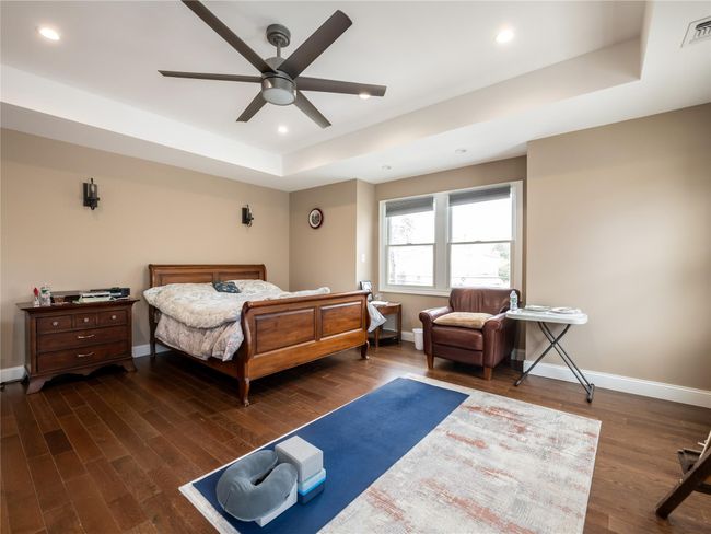 Bedroom with a tray ceiling, wood finished floors, and baseboards | Image 17