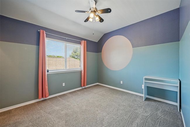 Carpeted spare room featuring lofted ceiling, ceiling fan, and baseboards | Image 31