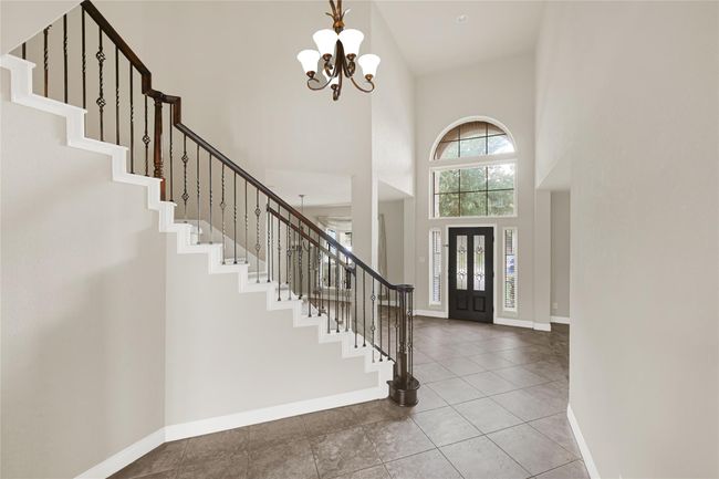 The two-story foyer feels bright and expansive, with natural light streaming through large windows and highlighting the height and openness of the space. | Image 6