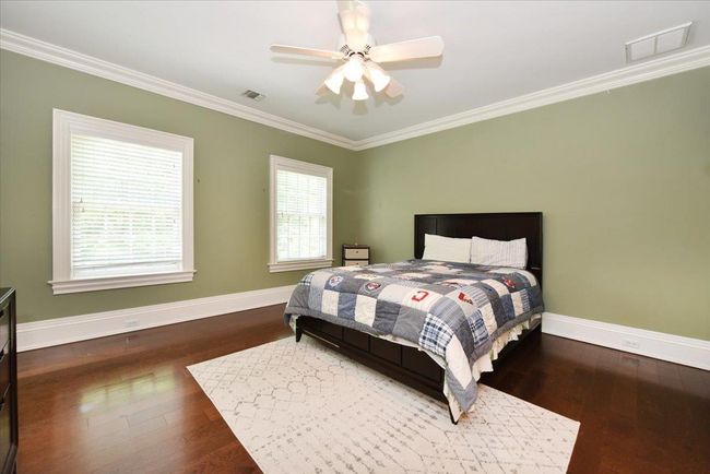 Bedroom featuring ornamental molding, wood finished floors, and a ceiling fan | Image 27