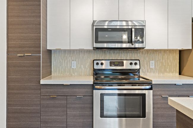 Kitchen with appliances with stainless steel finishes, modern cabinets, light countertops, and white cabinetry | Image 8