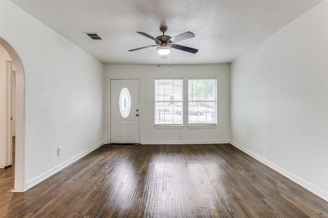 Entrance foyer featuring arched walkways, wood finished floors, ceiling fan, and a textured ceiling | Image 9