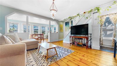 Living room with a chandelier and light wood-type flooring | Image 3