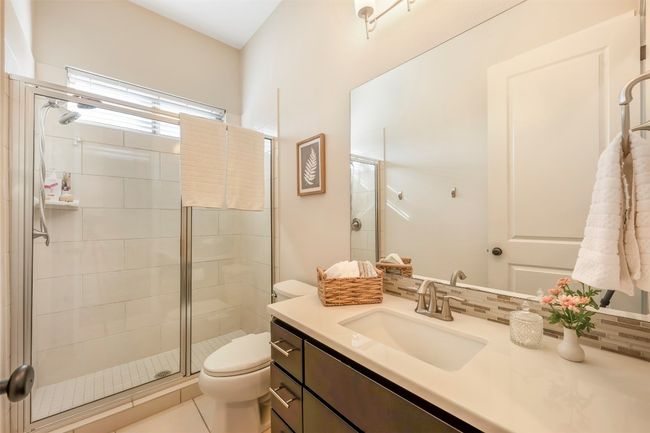 Full bathroom featuring vanity, a shower stall, decorative backsplash, and tile patterned floors | Image 9